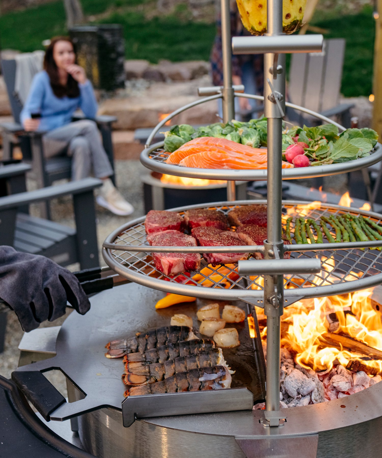 Food on multi tiered breeo smokeless firepit with fire