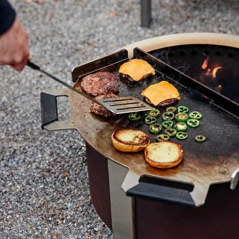 This is an image of a person getting ready to flip burgers on the Flat Top Griddle