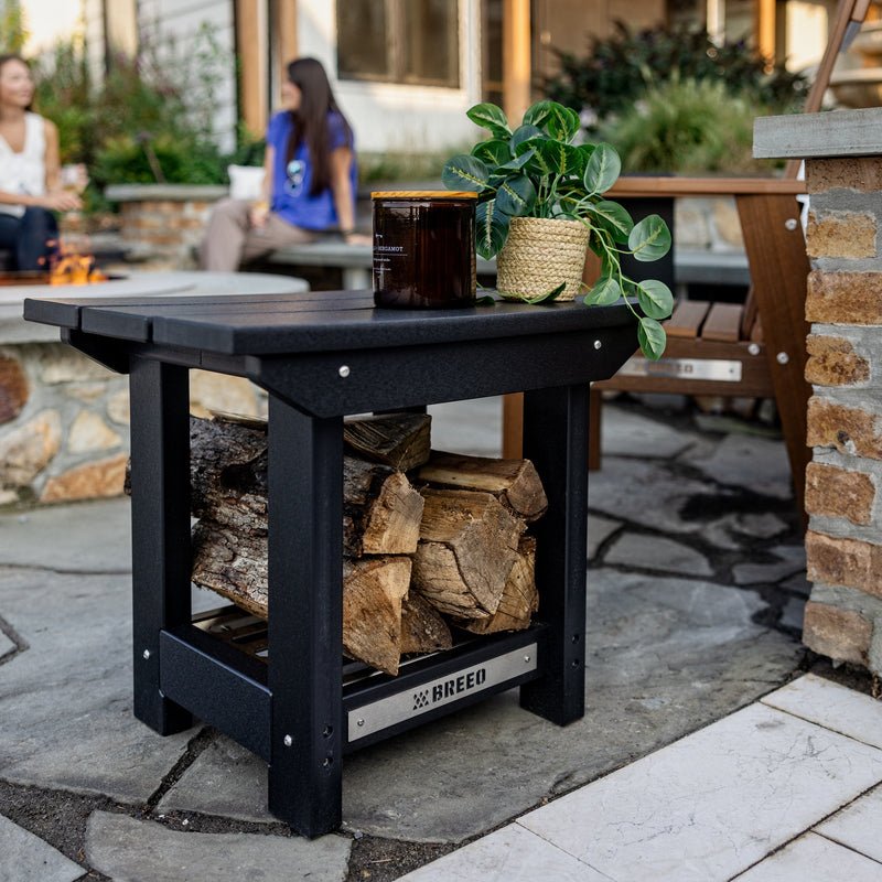 An image of the X Series Side Table set up on the patio near a Breeo Firepit