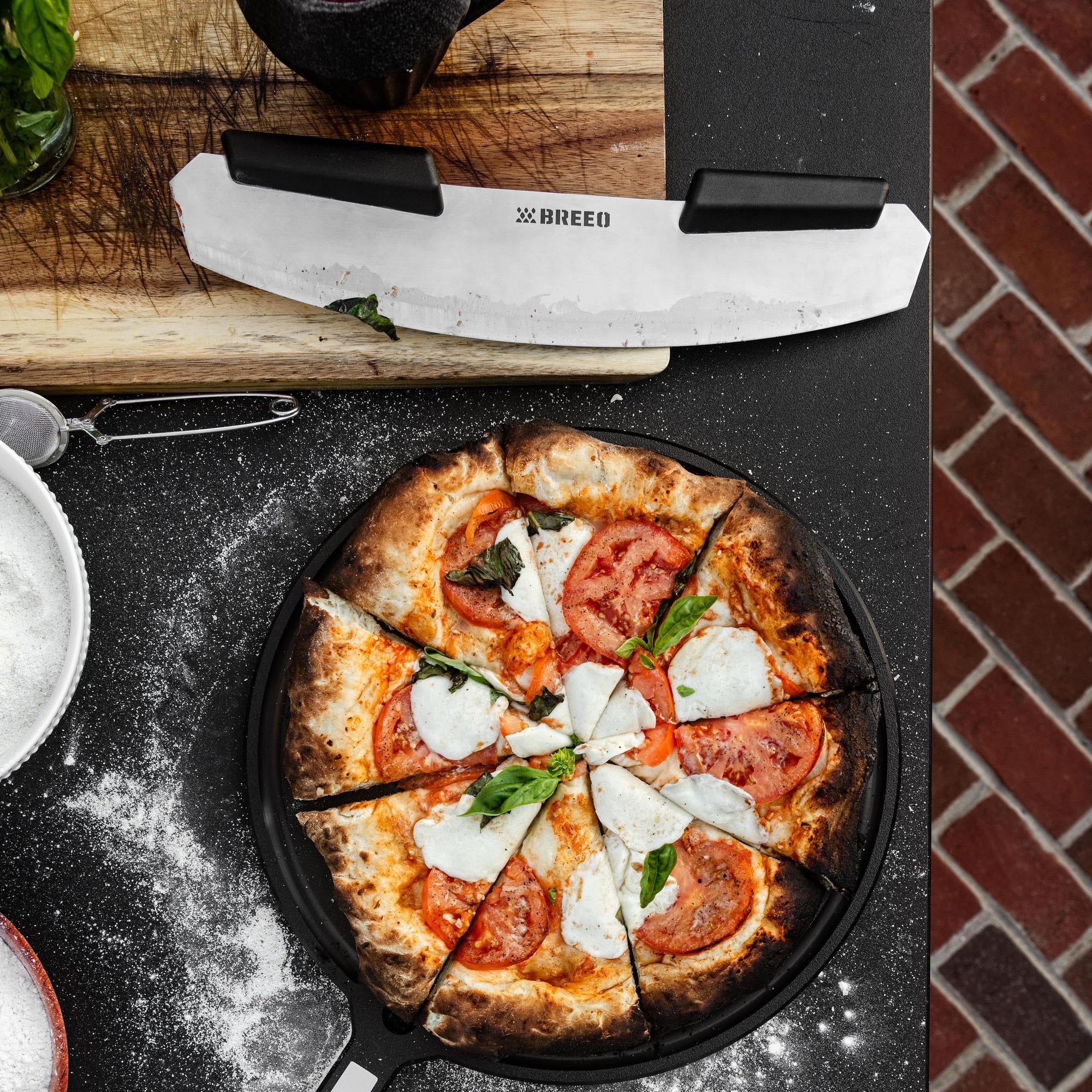 This is an image of the Breeo Pizza Rocker next to a fresh baked pizza on the Breeo Serving Board