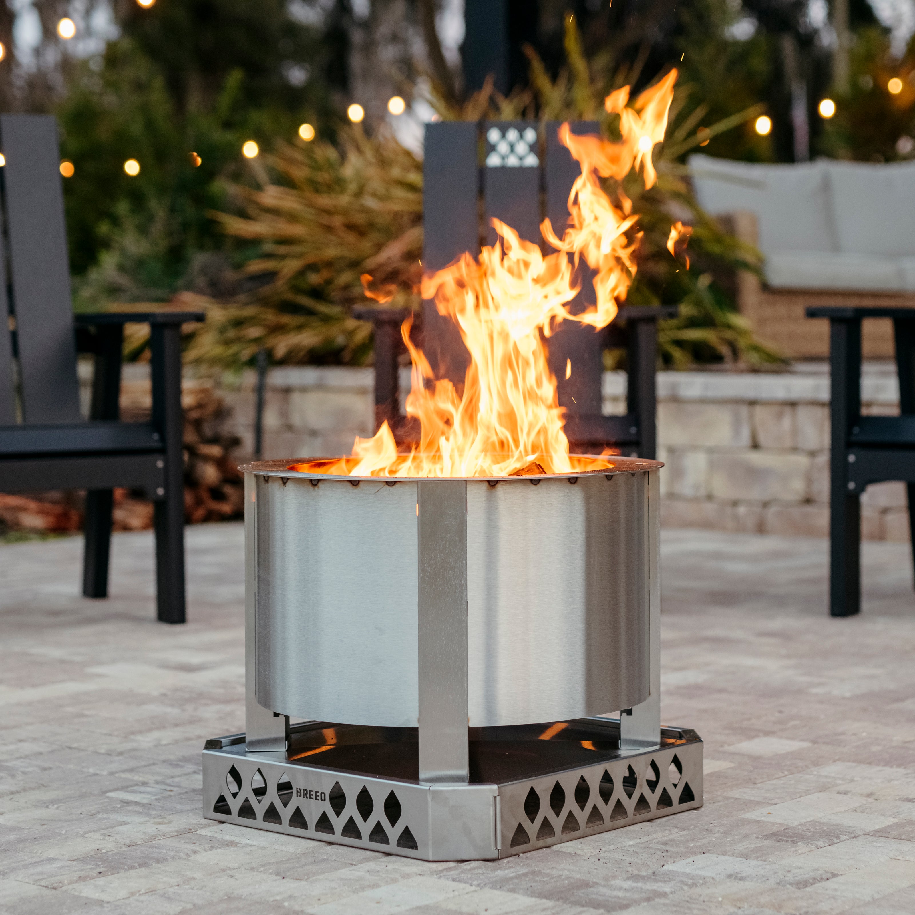 Breeo smokeless fire pit with fire on patio outside with blurred background