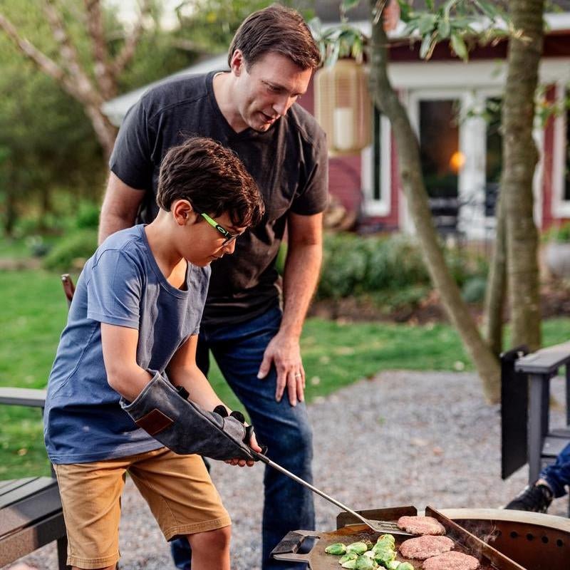 This is an image of a man helping his son grill burgers on the Flat Top