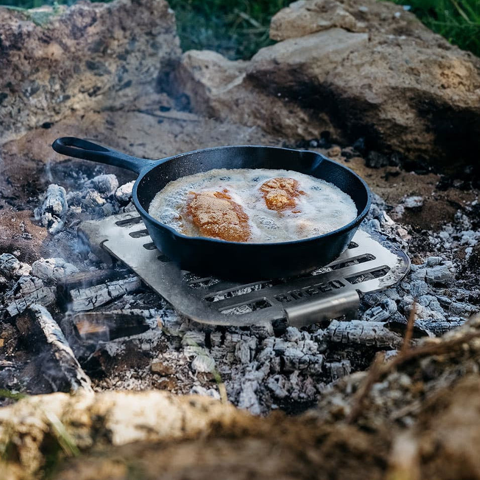A Breeo Skillet Rest over a bed of hot coals used to fry chicken.