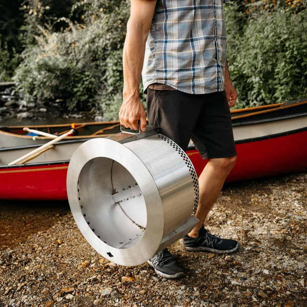 An image of a man carrying the Y Series Firepit