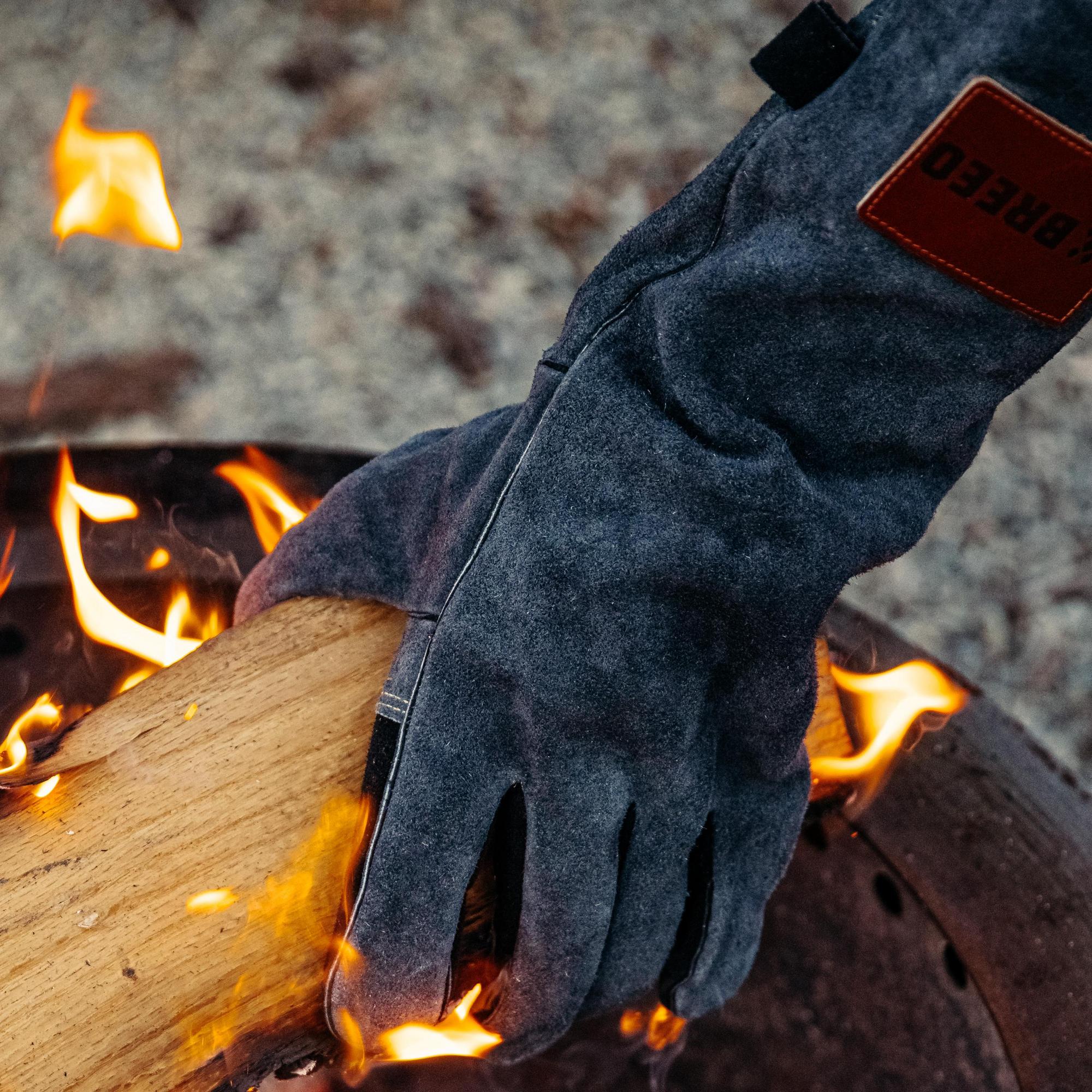 An image of the Breeo Leather Fire Gloves used to remove a log from the fire