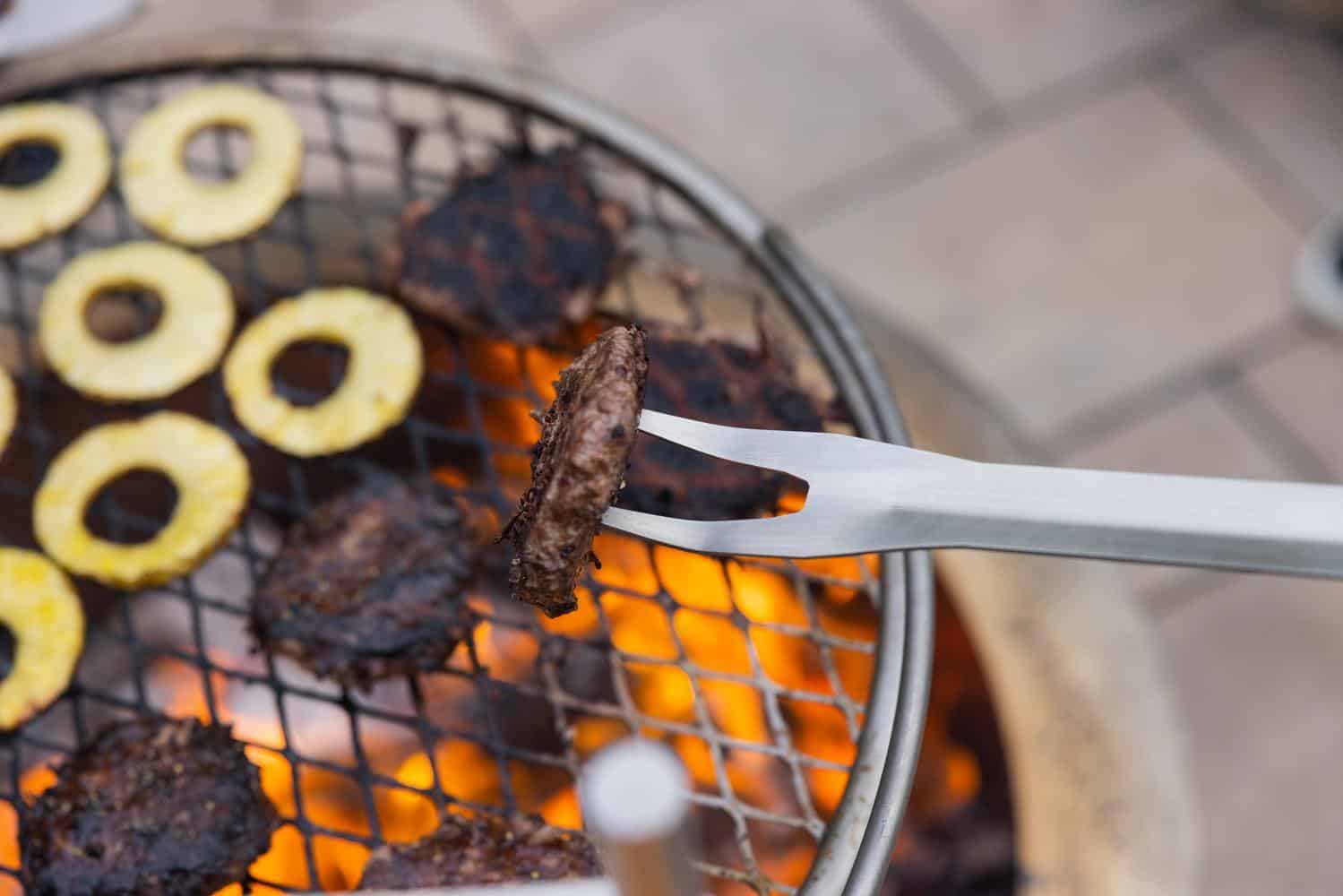 Using a fork to flip burgers on the Outpost Grill