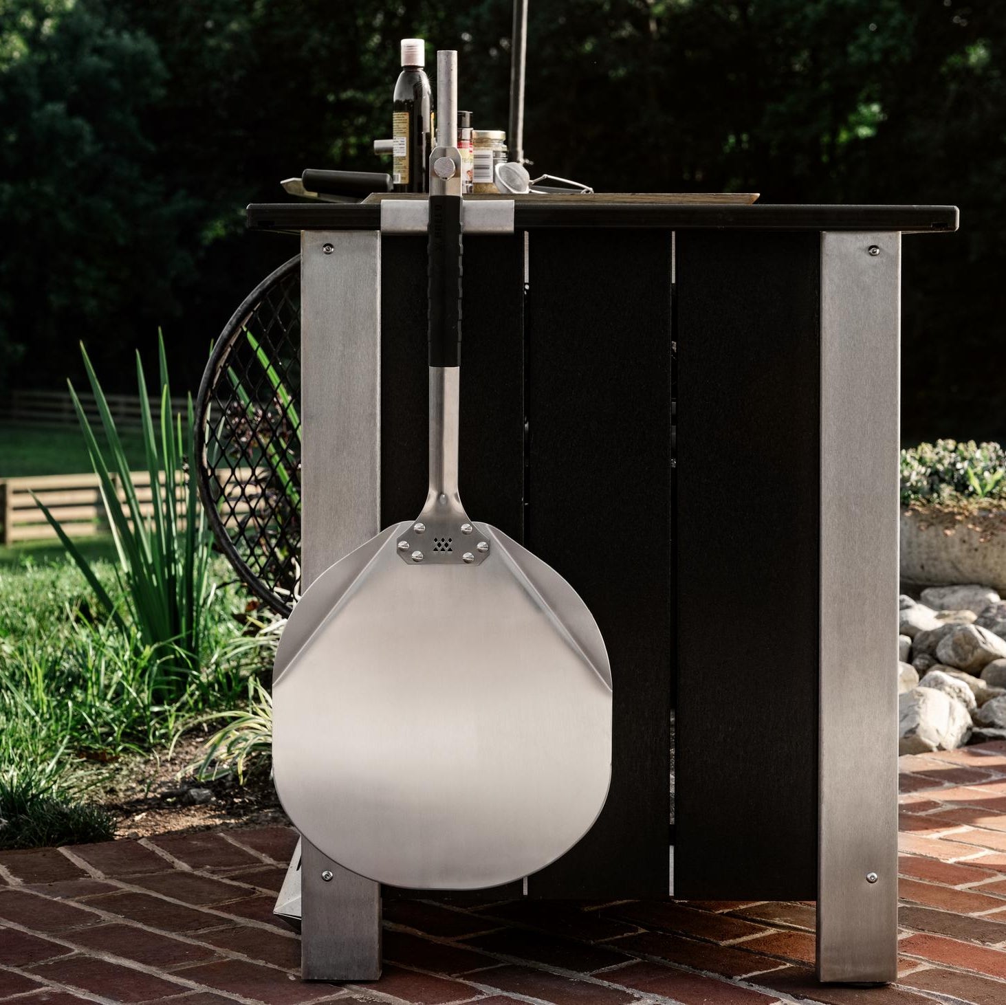  Breeo Pizza Peel hanging from an X Series Table with an Outrig Post