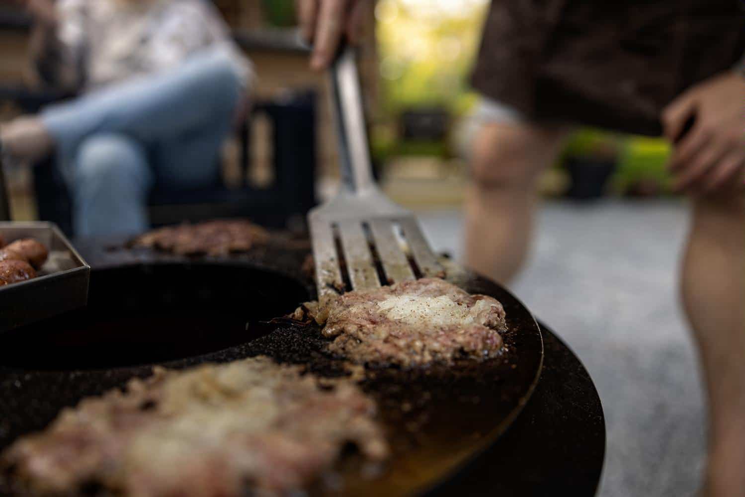 Using a Breeo Spatula to flip a burger on the Searplate Griddle 