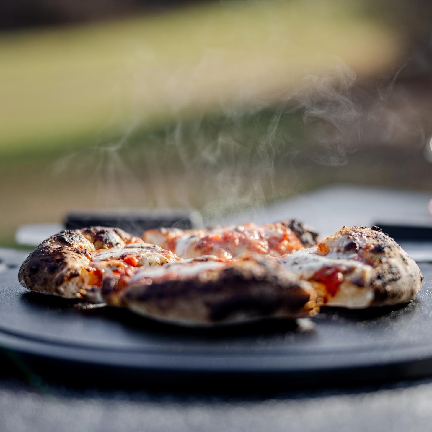 This is an image of fresh baked pizza served on thethe Breeo Serving Board