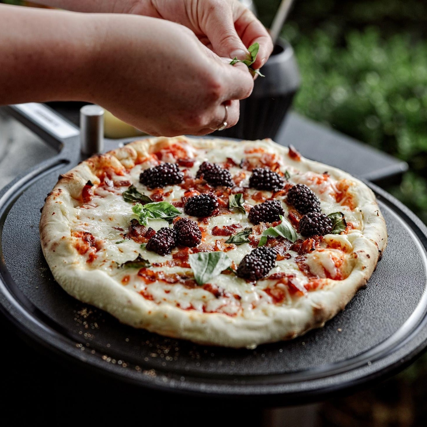 This is an image of fresh pizza sitting on the Breeo Serving Board