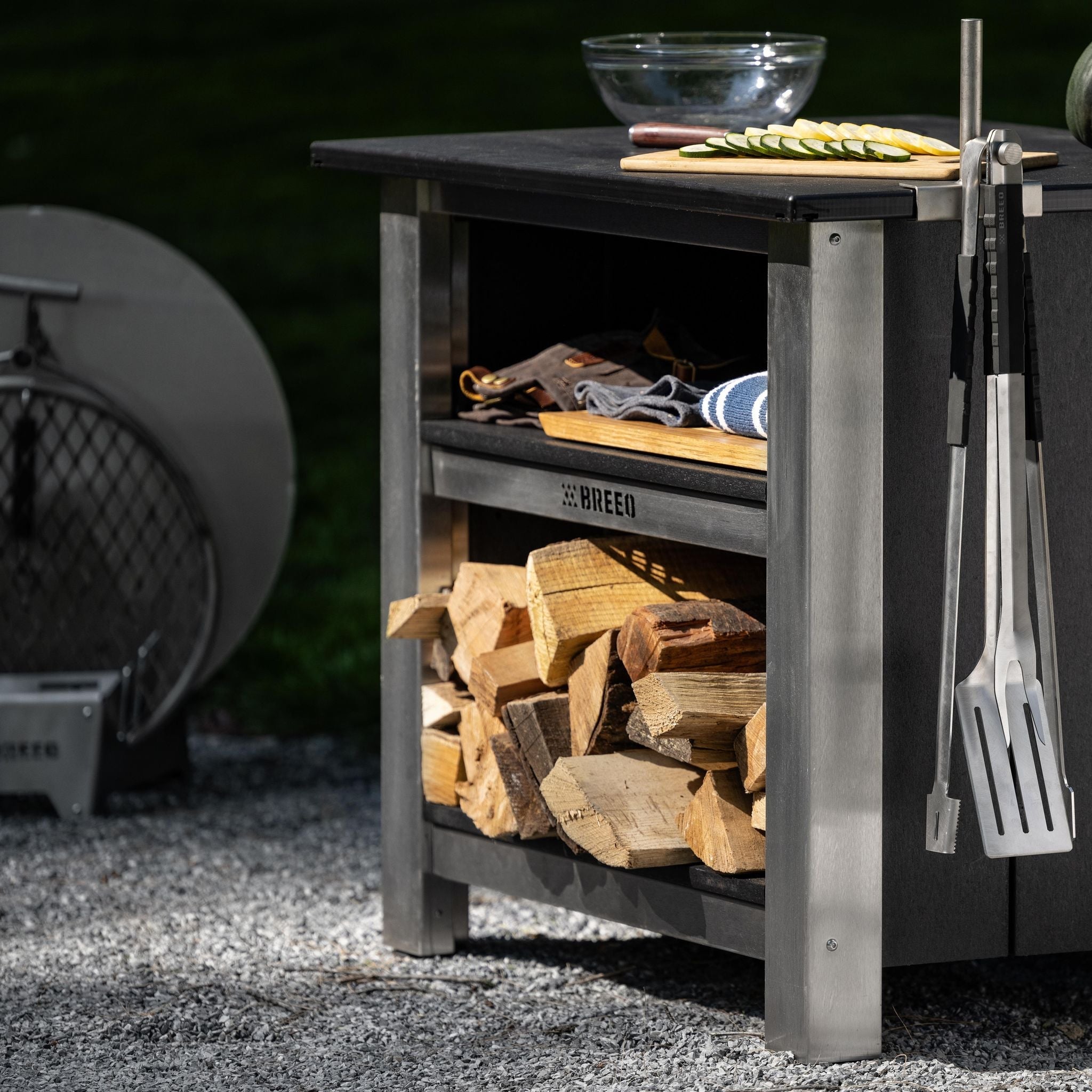 This is an image of the X Series Table with an Outrig Post attached,  with Grilling Tools hanging on the side