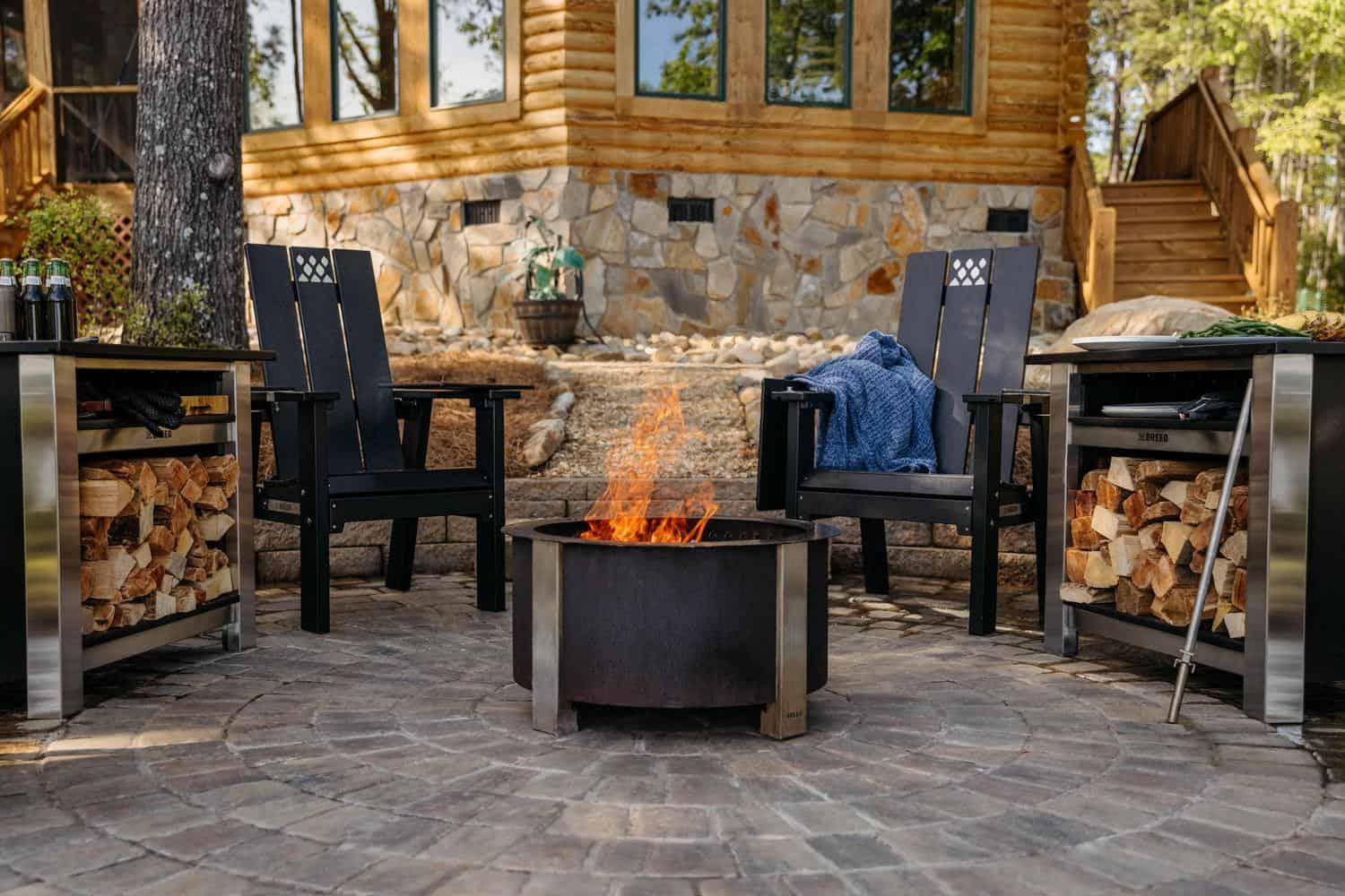 This is an image of an X Series firepit with X Series Chairs and Tables set up around the fire. 