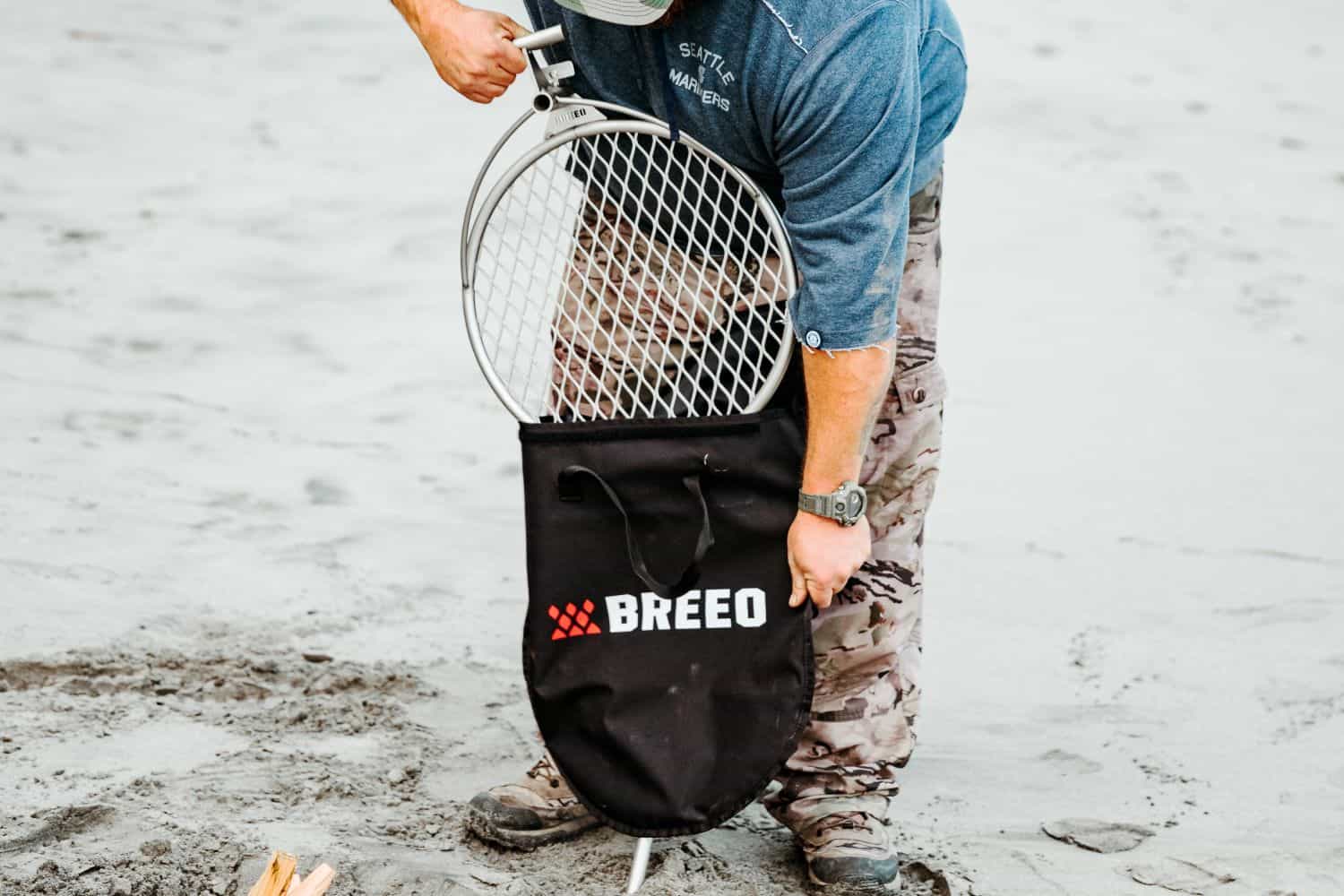An image of a person removing the Outpost Grill from it's carrying bag. 